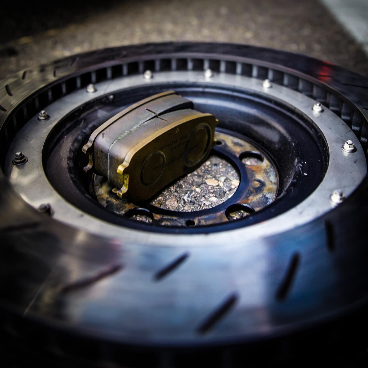A brake pad seated against a brake disc, close up